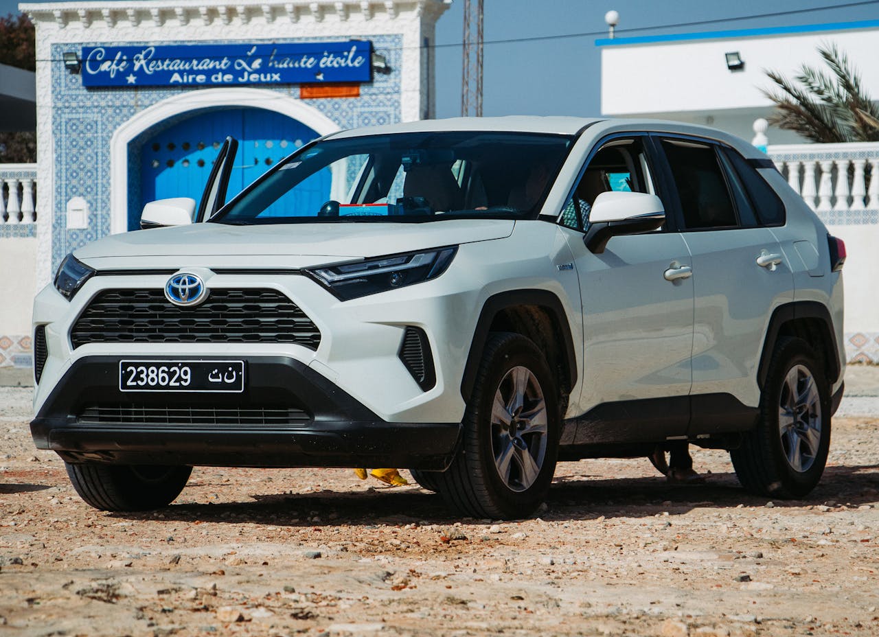 White Toyota car parked at Cafe Restaurant La'huite etoile in Mahdia, Tunisia. Bright sunny day outdoor setting.