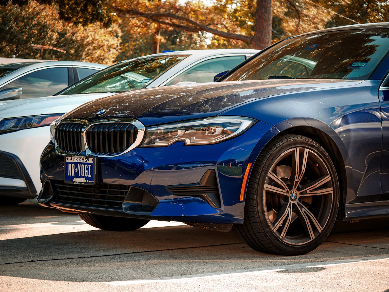 Blue BMW 330i parked outdoors in Arlington, Texas, under sunny skies.