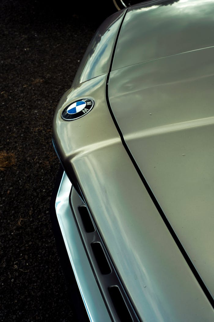 Detailed close-up of a vintage BMW car hood emblem emphasizing classic design.
